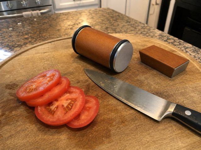 Sliced tomato on a wooden board beside the Keldley roller and angle block