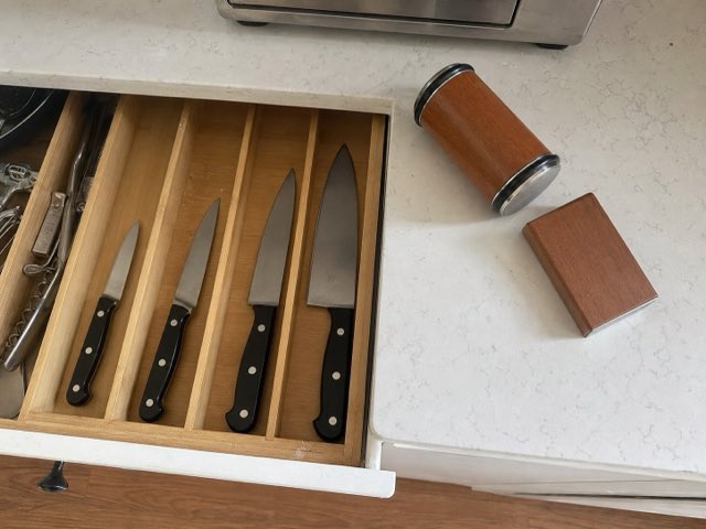 Open kitchen drawer of straight-edge knives next to the Keldley roller and angle block