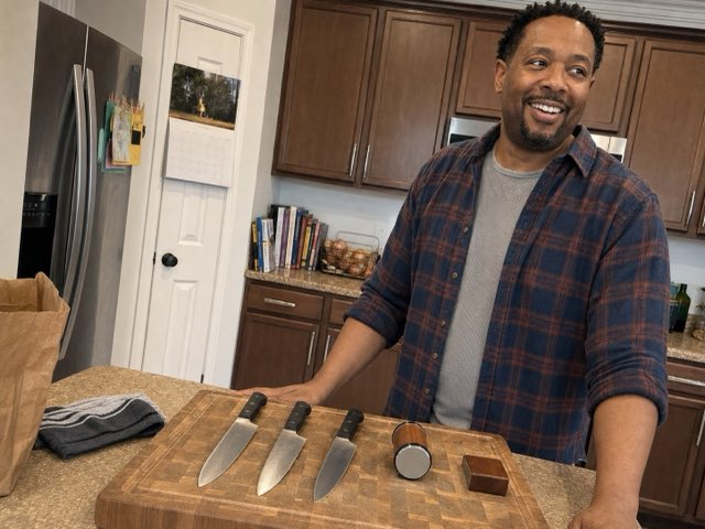 Customer with three sharpened chef's knives on a board beside the Keldley roller and block